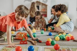 Kinder verschiedenen Alters spielen auf dem Boden