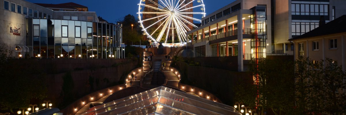 Novembermarkt Riesenrad im Hintergrund beleuchtet im dunkeln 