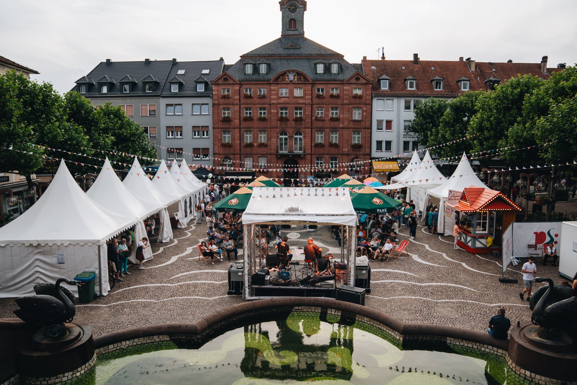 Schloßplatz von oben, viele Stände, bunte Wimpelkette, reges Treiben