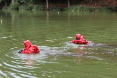 Zwei Feuerwehrleute schwimmen in Chemikalienschutzanzug 