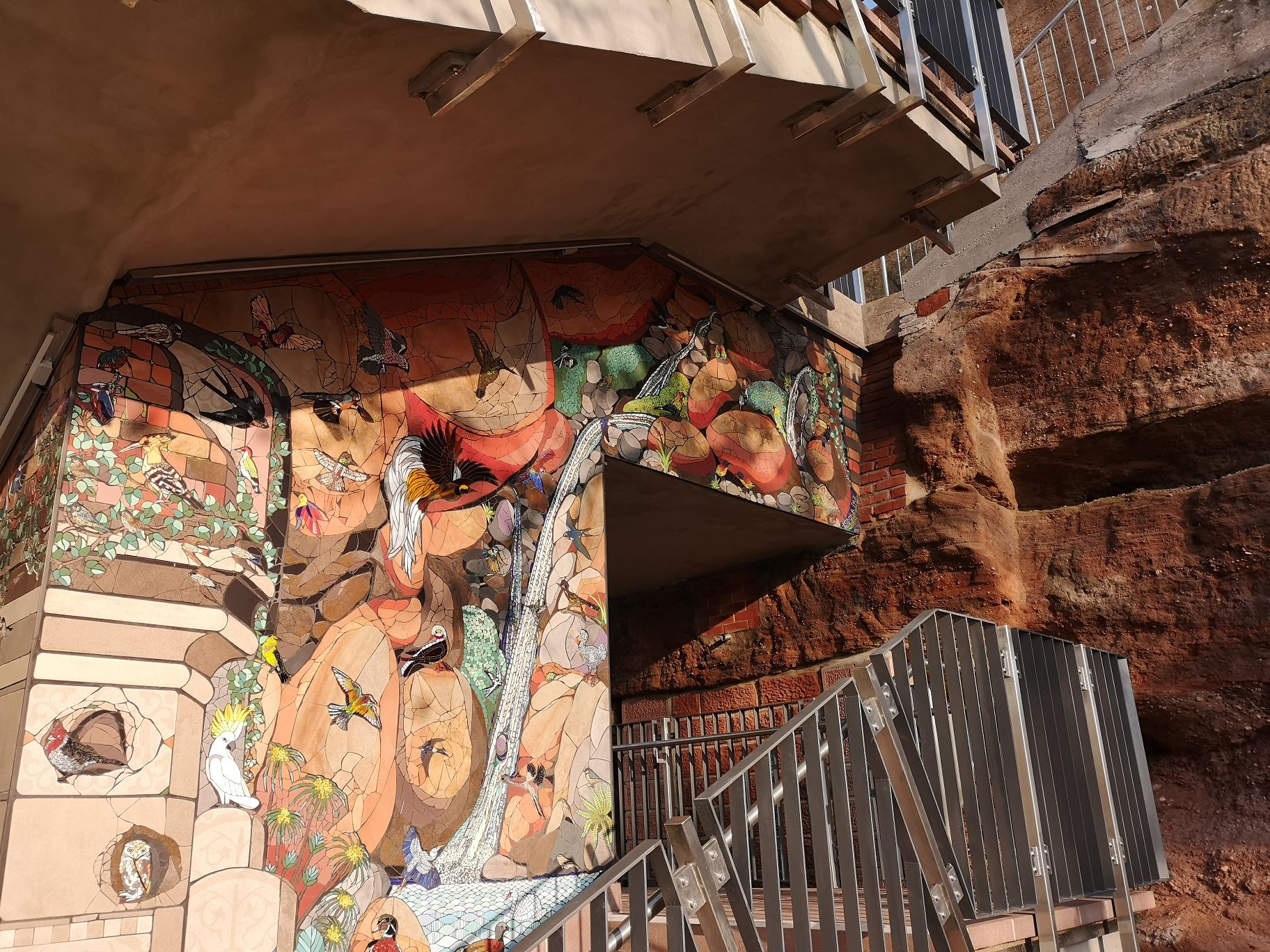 Nahafnahme des Mosaiks mit verschiedenen Vogelarten aus aller Welt an der Felsentreppe