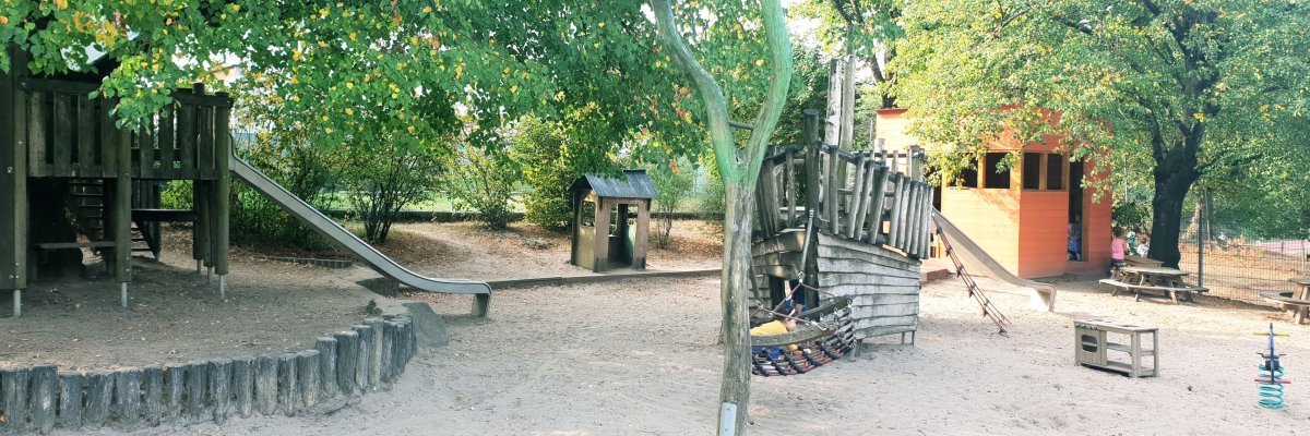 Abgebildet ist das Außengelände der Kita mit Spielgerüst