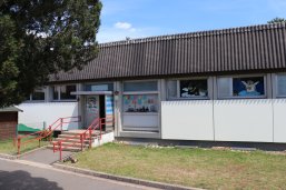 KiTa Samselo Abgebildet ist der Eingangsbereich der Kita mit Wandgemälde (verschiedene Jahreszeitenmotive vom Samselo) und Treppenaufgang