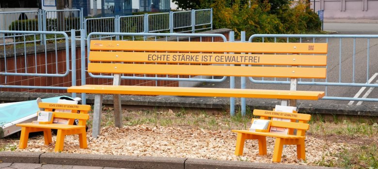 Orangefarbene Bank mit der Aufschrift Echte Stärke ist gewaltfrei