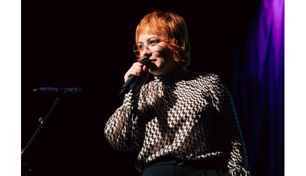 Best Of Poetry Slam Eine Dame mit kurzen Haaren und Brille redet in ein Mikrofon