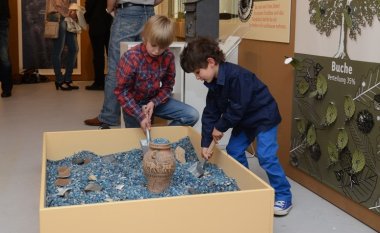 Zwei Kinder an Mitmachstation: Experimentelle Archäologie 