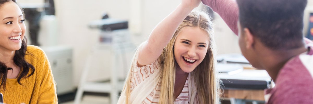 Schüler im Klassenraum geben sich Handschlag 