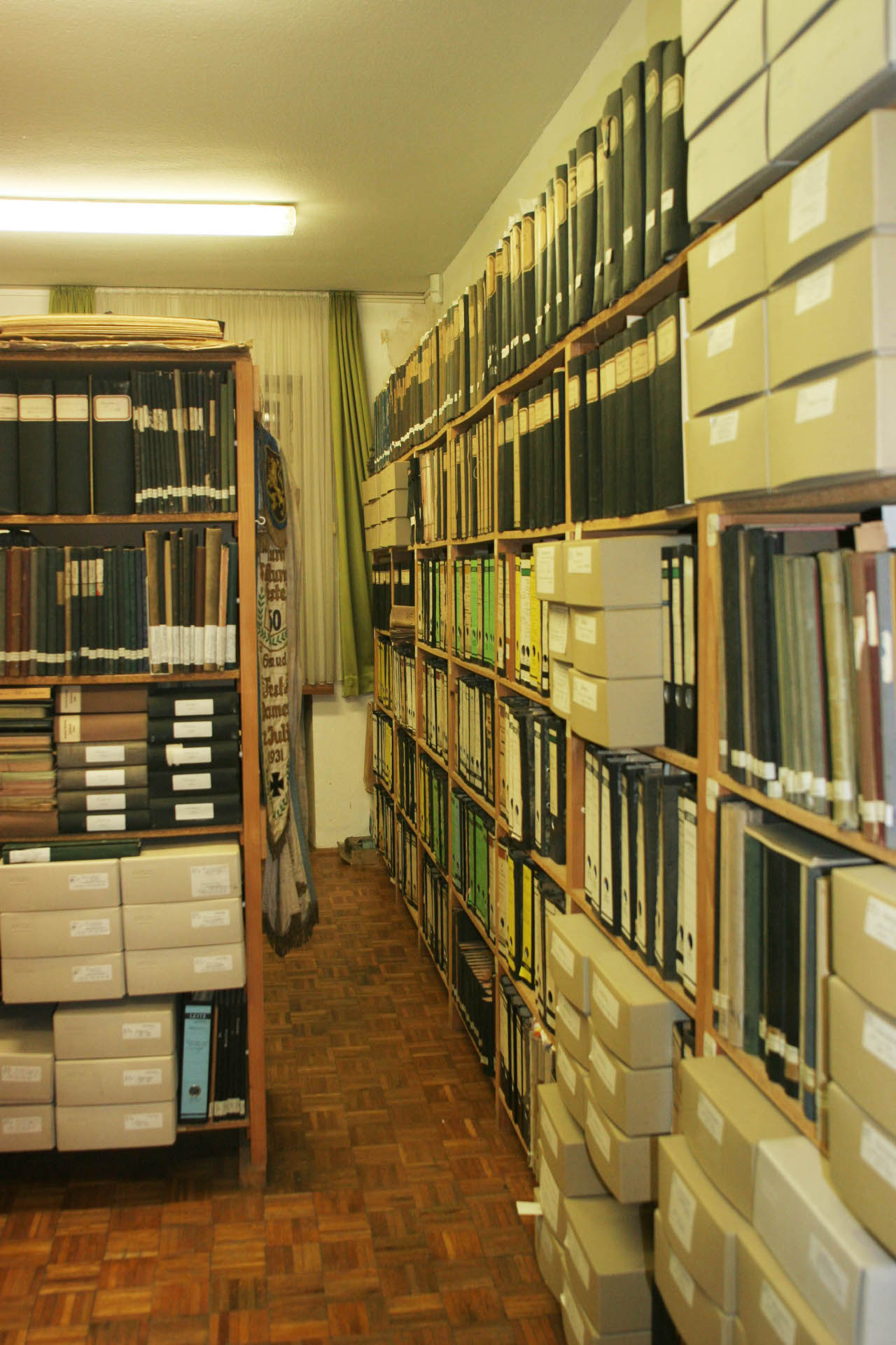 Regale mit Kisten und Dokumenten: Das Archivgut im ehemaligen Erlenbrunner Rathaus wird derzeit an den neuen zentralen Standort in die Messehalle verlegt.