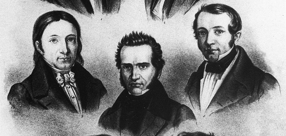 Das Bild zeigt eine historische Schwarz-Weiß-Lithografie mit den Porträts von sieben Männern, die in drei Reihen angeordnet sind. Sie tragen die für das frühe 19. Jahrhundert typische Kleidung mit dunklen Mänteln, hohen Kragen und Halstüchern. Die Personen blicken jeweils in unterschiedliche Richtungen und sind als Brustbilder dargestellt. Unter den Porträts befinden sich handschriftliche Namensangaben. Die Darstellung vermittelt den Eindruck einer Sammlung bedeutender Persönlichkeiten oder Gelehrter aus dieser Epoche.