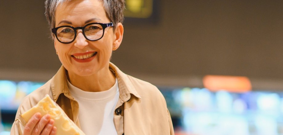 Happy woman buying cheese and fresh groceries