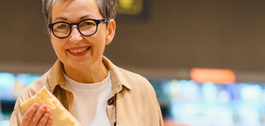 Happy woman buying cheese and fresh groceries