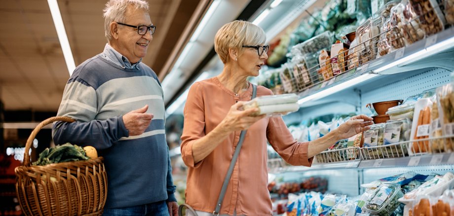 Mature husband and wife buying groceries in supermarket.