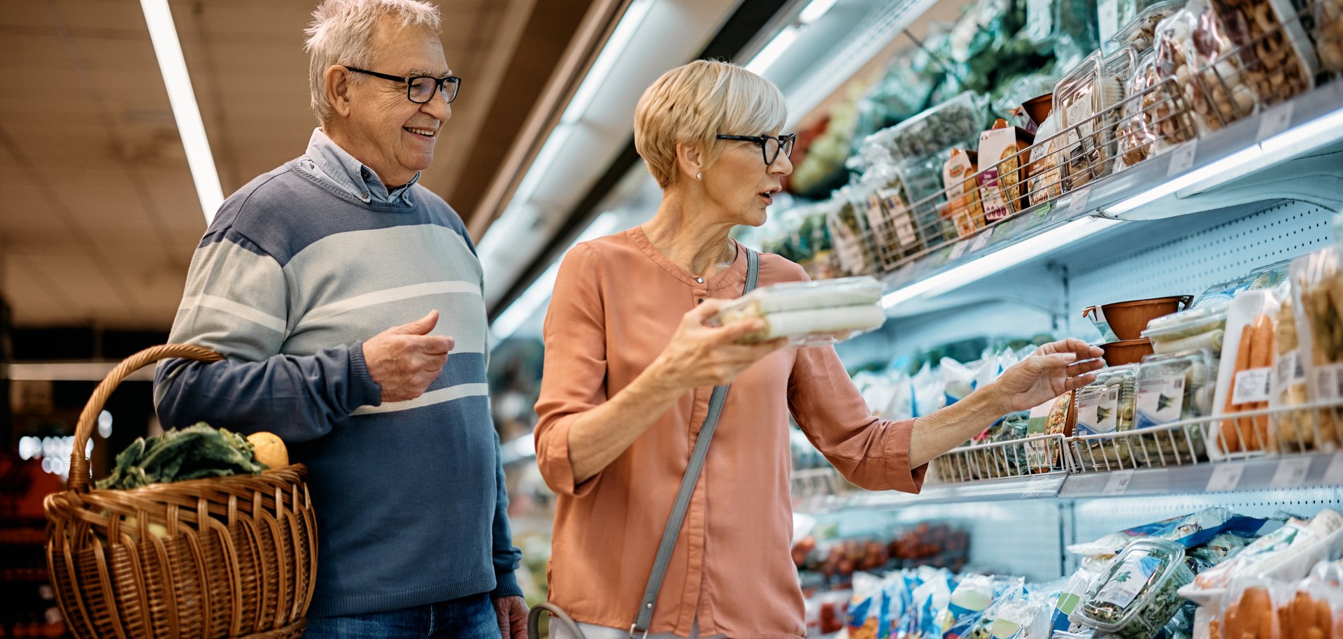 Mature husband and wife buying groceries in supermarket.