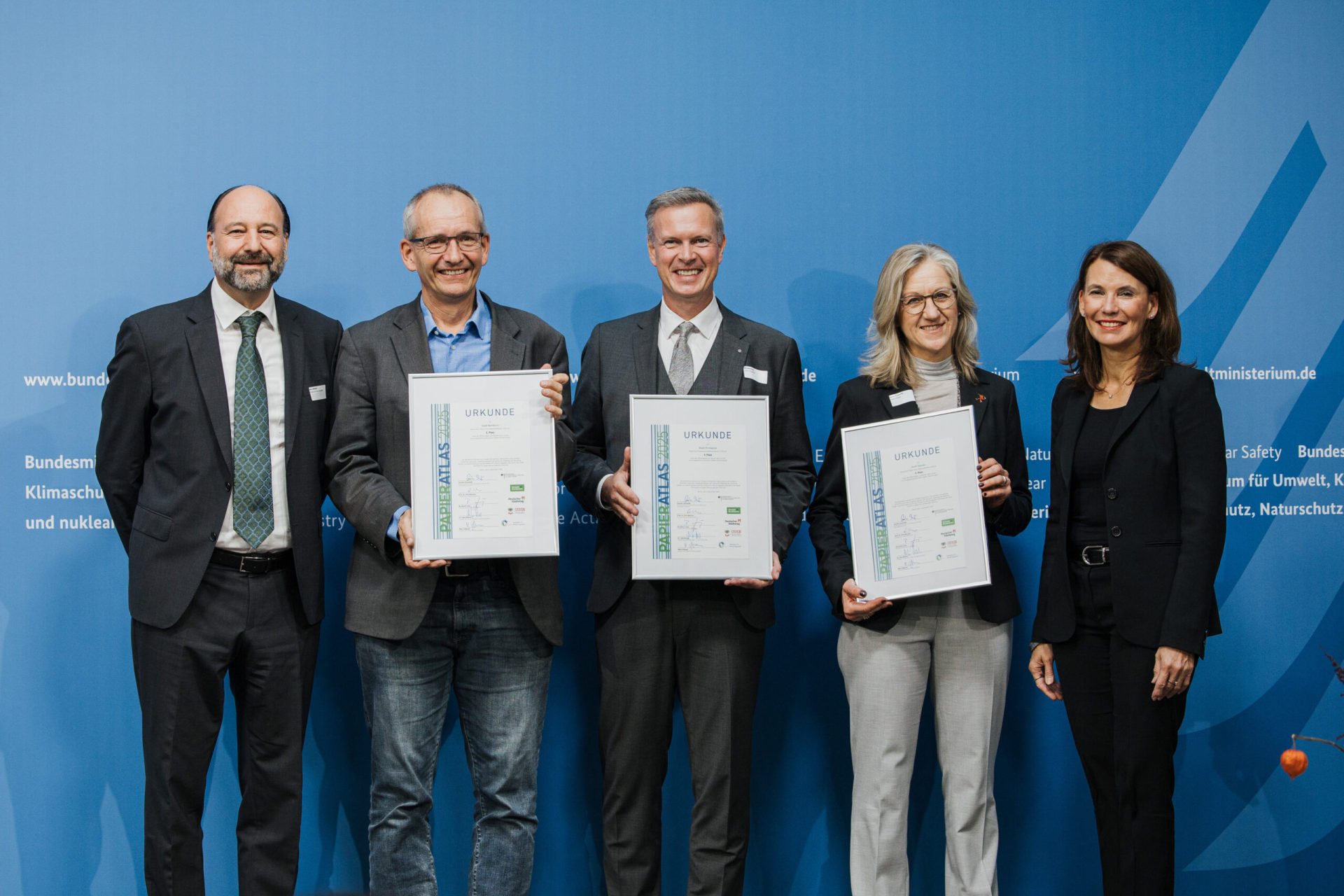 Ehrung der Städte Nordhorn, Pirmasens und Hameln auf dem 3. Platz der "Recyclingpapierfreundlichsten Mittelstädte" 2025, v.l.n.r.: Marc Gebauer (Sprecher der Initiative Pro Recyclingpapoer), Markus Schlie (Erster Stadtrat der Stadt Nordhorn), Michael Maas (Bürgermeister der Stadt Pirmasens), Barbara Schulte (Umwelt und Klimaschutz der Stadt Hameln), Parlamentarische Staatssekretärin Rita Schwarzelühr-Sutter