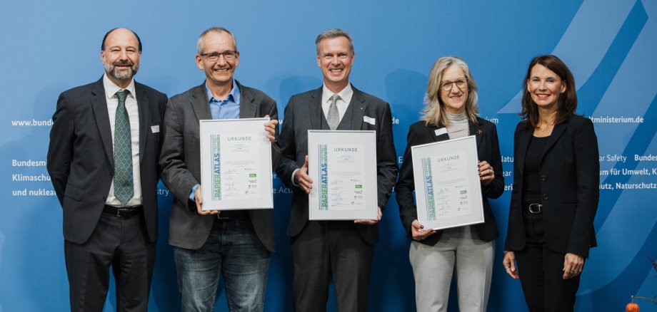 Ehrung der Städte Nordhorn, Pirmasens und Hameln auf dem 3. Platz der "Recyclingpapierfreundlichsten Mittelstädte" 2025, v.l.n.r.: Marc Gebauer (Sprecher der Initiative Pro Recyclingpapoer), Markus Schlie (Erster Stadtrat der Stadt Nordhorn), Michael Maas (Bürgermeister der Stadt Pirmasens), Barbara Schulte (Umwelt und Klimaschutz der Stadt Hameln), Parlamentarische Staatssekretärin Rita Schwarzelühr-Sutter Ehrung der Städte Nordhorn, Pirmasens und Hameln auf dem 3. Platz der "Recyclingpapierfreundlichsten Mittelstädte" 2025, v.l.n.r.: Marc Gebauer (Sprecher der Initiative Pro Recyclingpapoer), Markus Schlie (Erster Stadtrat der Stadt Nordhorn), Michael Maas (Bürgermeister der Stadt Pirmasens), Barbara Schulte (Umwelt und Klimaschutz der Stadt Hameln), Parlamentarische Staatssekretärin Rita Schwarzelühr-Sutter