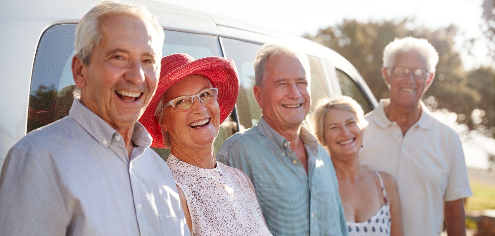 Portrait Of Senior Friends Standing Together Beside Van On Vacation