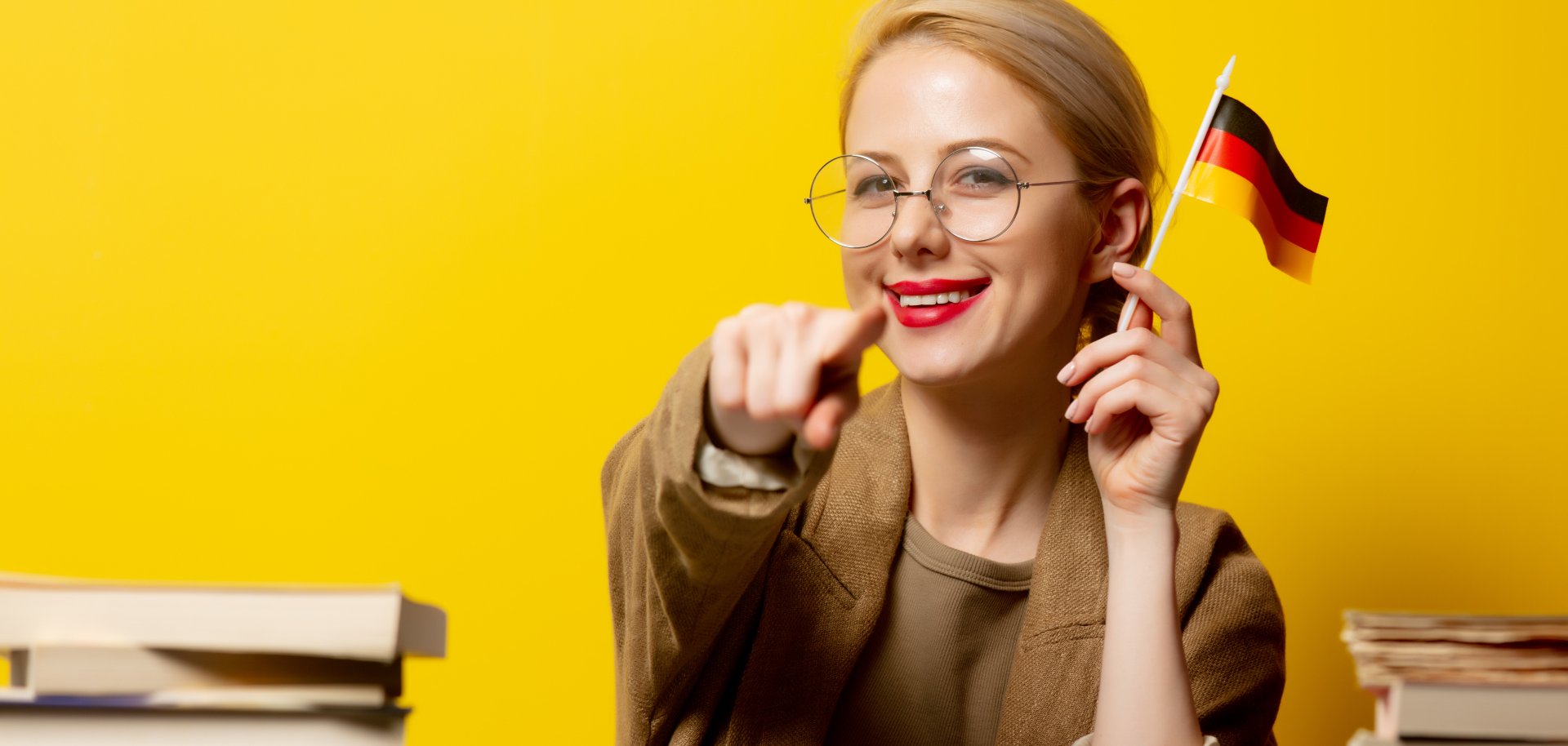 Style blonde woman sitting at table with books and flag of Germa Style blonde woman sitting at table with books and flag of Germa