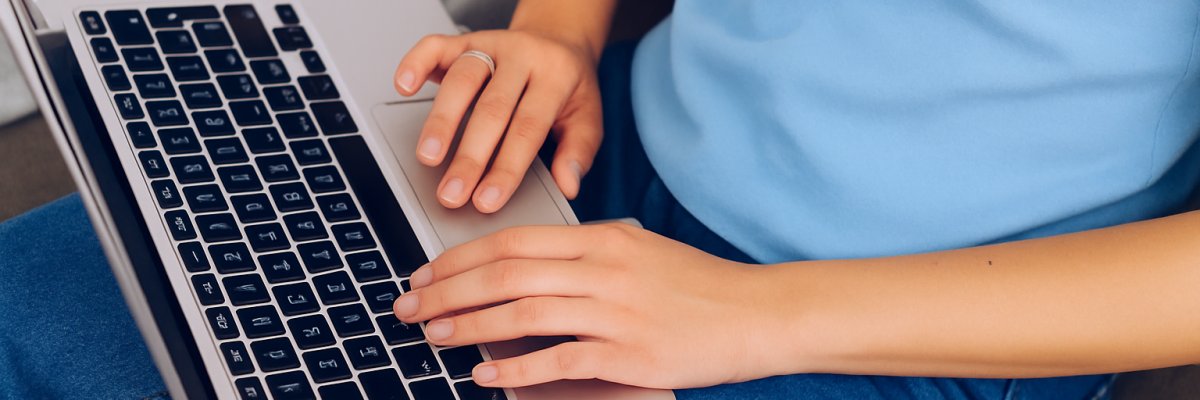 Junge Frau arbeitet am Laptop von zuhause aus