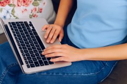 Junge Frau arbeitet am Laptop von zuhause aus