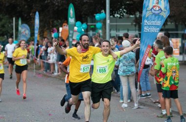 Firmenlauf Zwingerstraße zwei Männer freuen sich bei Zieleinlauf 