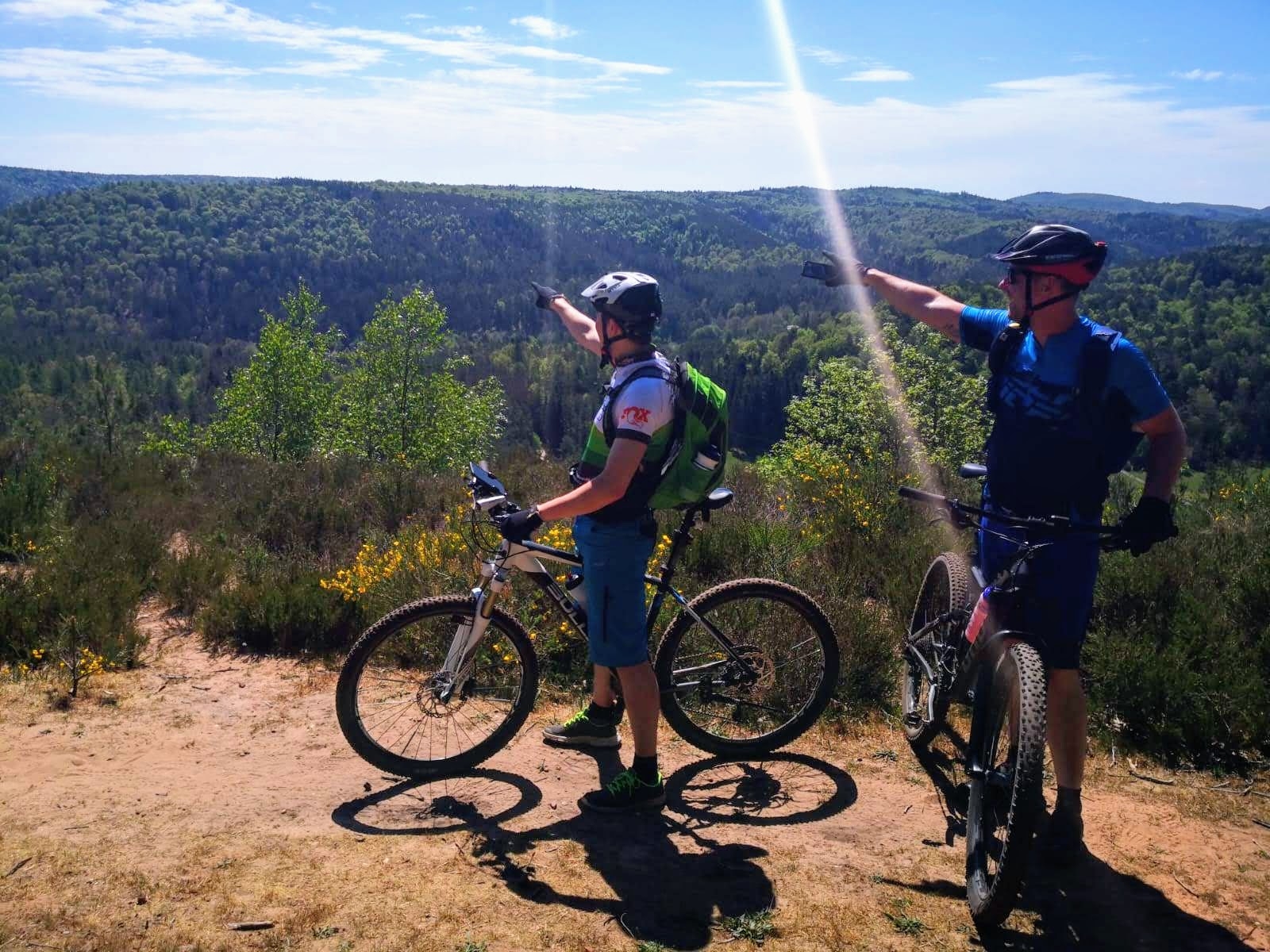 Zwei Mountainbiker - Aussicht Zwei Mountainbiker zeigen auf die schöne Aussicht