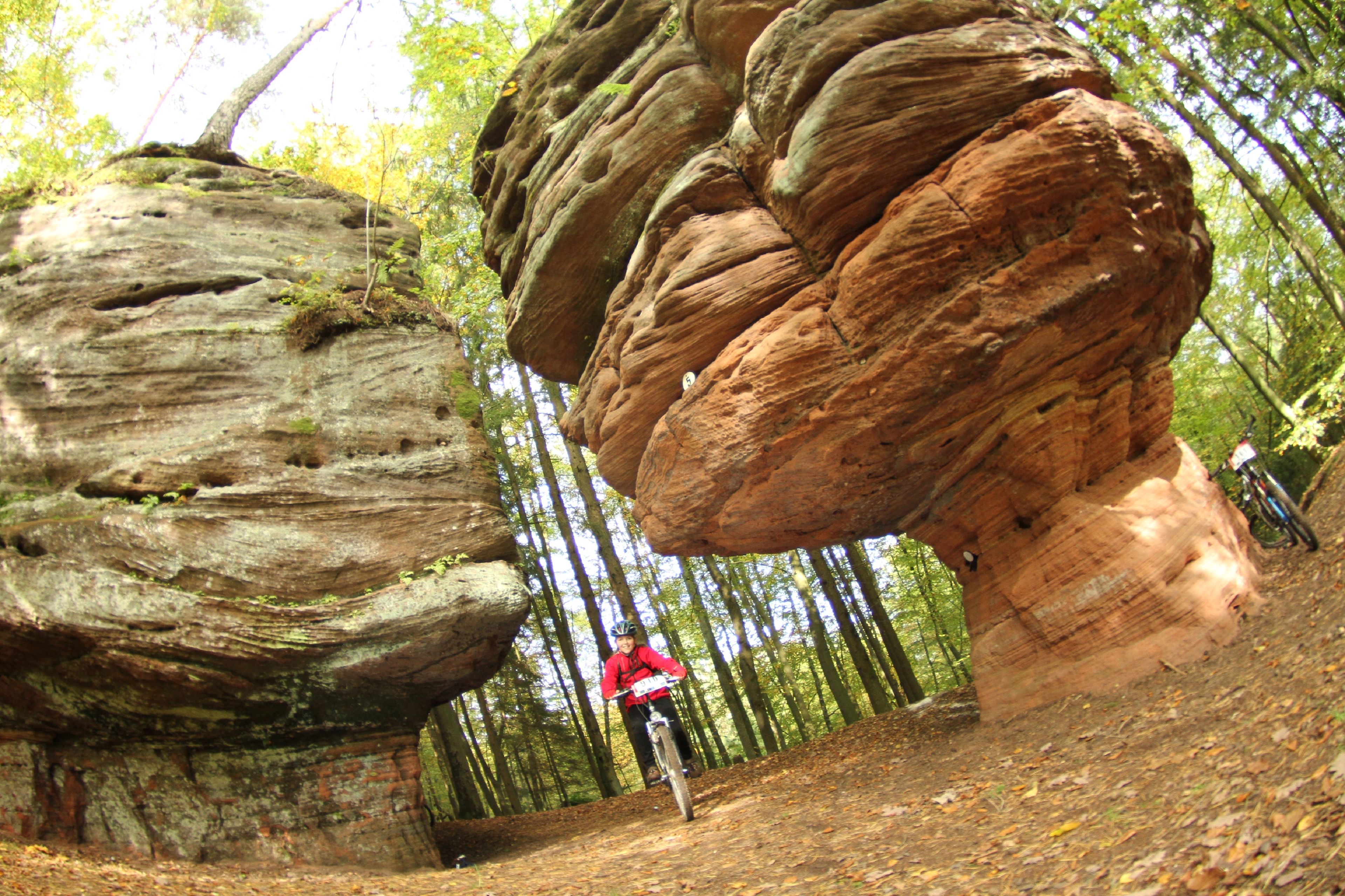 Frau fährt mit WasgauBike zwischen Felsen 