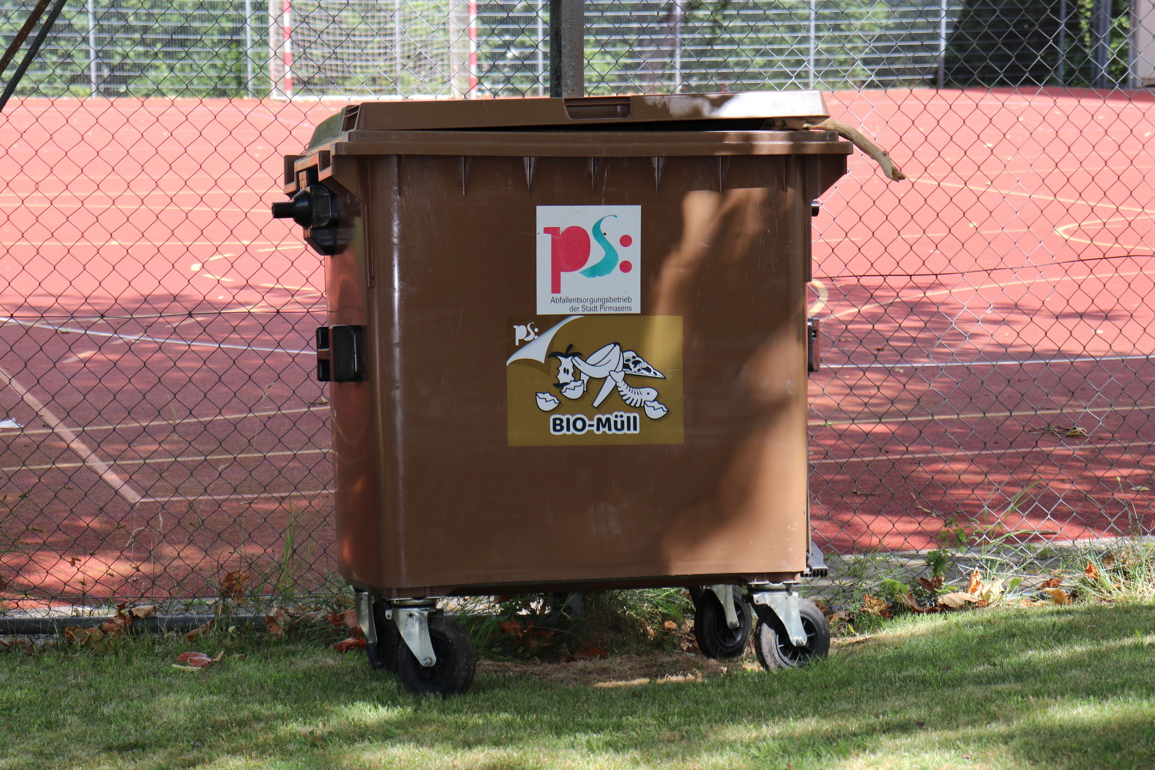 Braune Mülltonne mit Sticker 