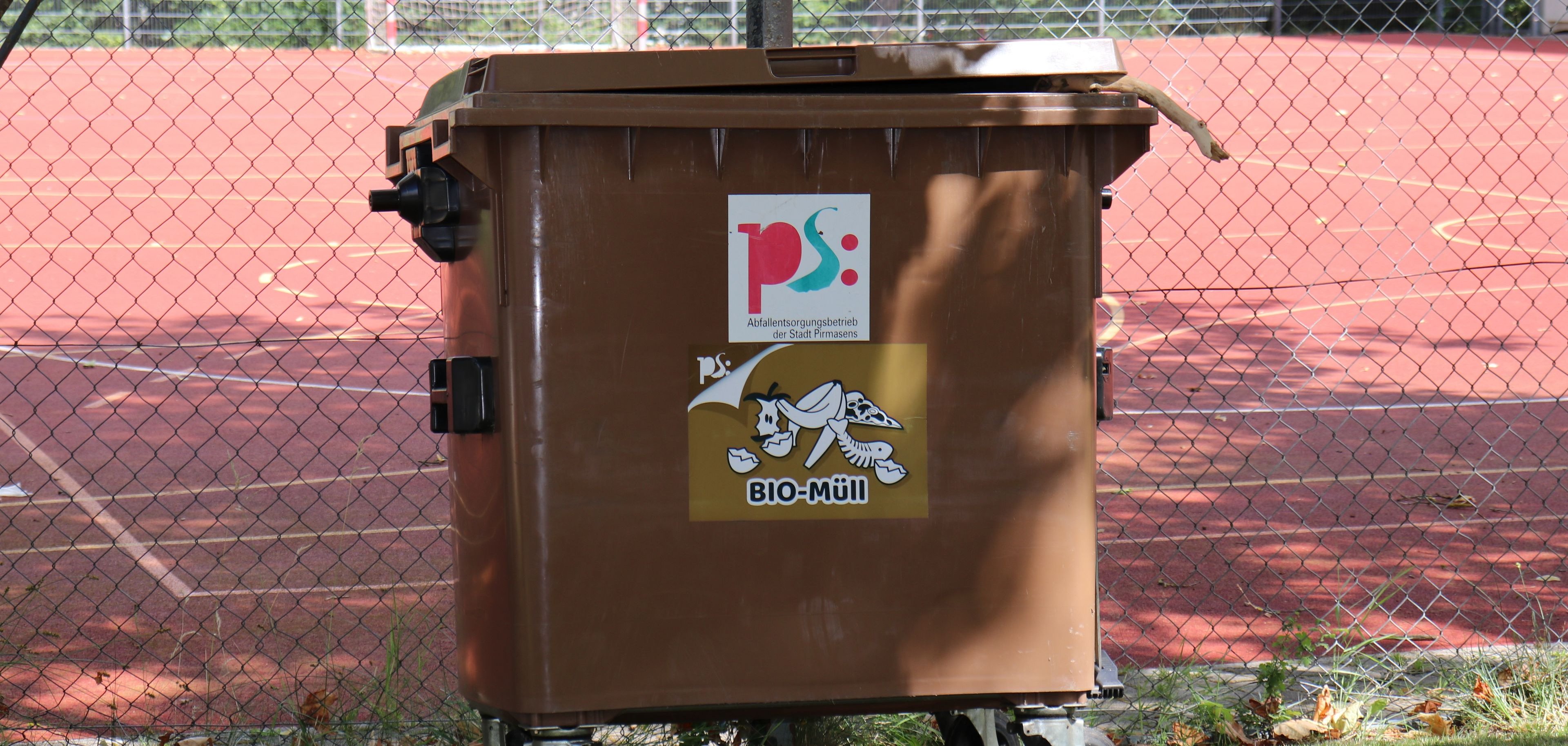 Braune Mülltonne mit Sticker 