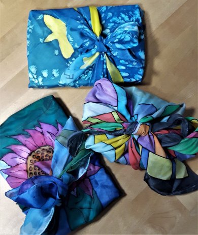 3 in bunte Tücher eingepackte Geschenke