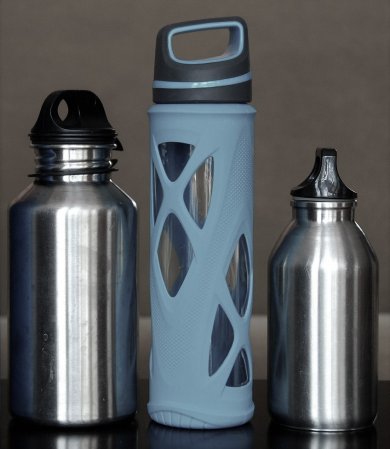 3 silberne Wasserflaschen, die mittlere mit einem blauen Netz ummantelt