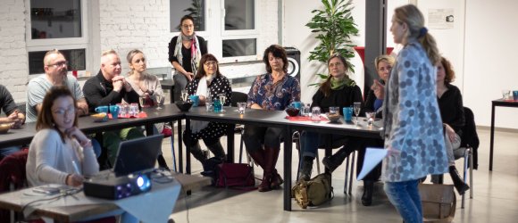 Teilnehmer lauschen der Referentin Pia Graf